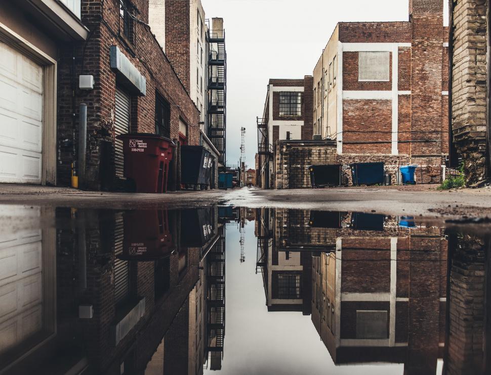 Free Image of Urban Buildings Reflected in Water Puddle 
