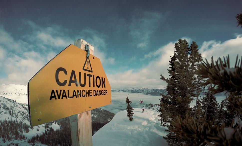 Free Image of Yellow Caution Sign on Snow Covered Mountain 