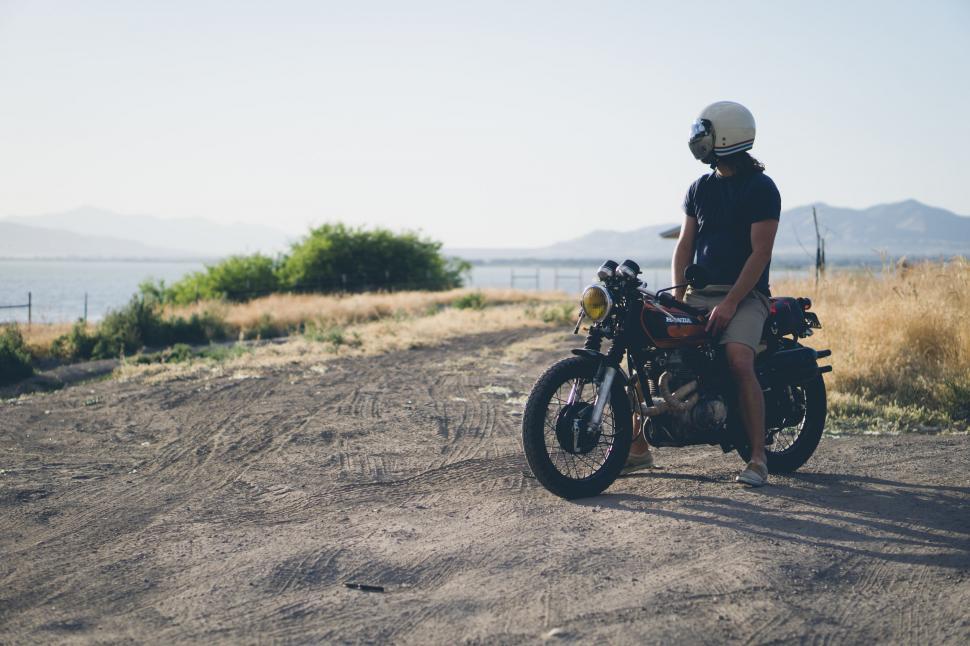 Free Image of Person Sitting on Motorcycle on Dirt Road 