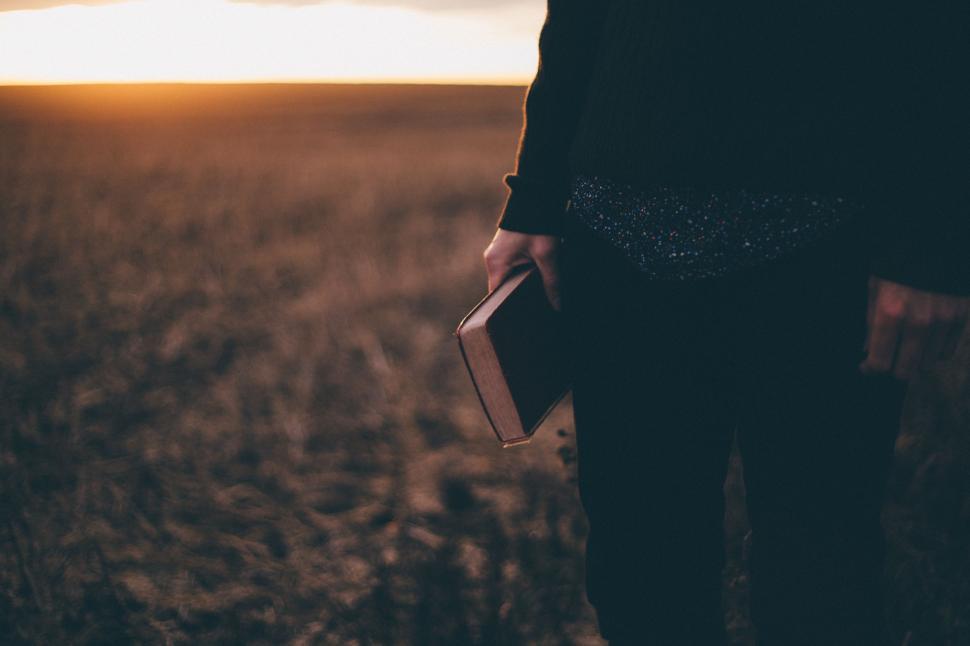 Free Image of Person Holding Book in Field 