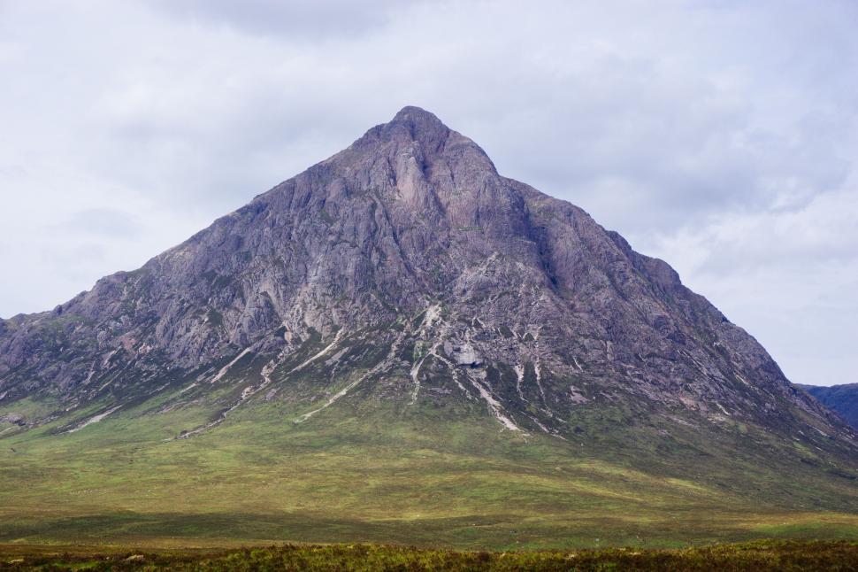 Free Image of A Very Tall Mountain in the Middle of a Field 