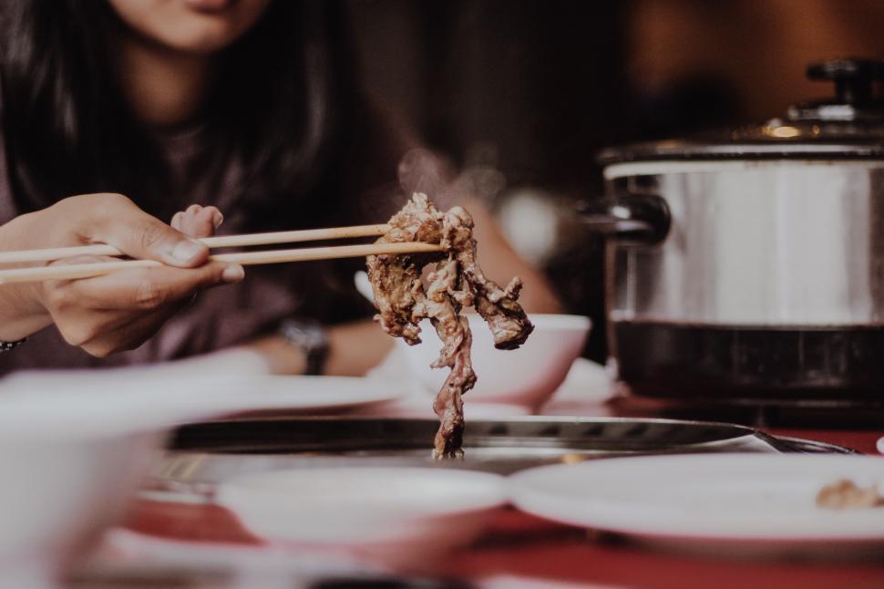 Free Image of Woman Holding Chopsticks Over Plate of Food 