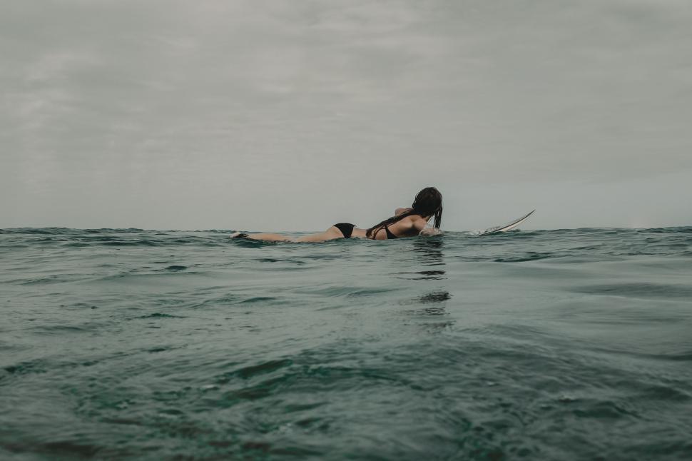Free Image of Person Laying on Surfboard in Ocean 