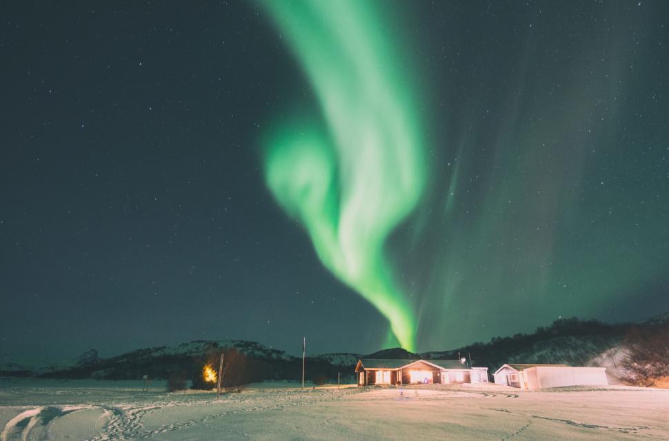 Free Image of Green Aurora Borealis Dancing Over Snow Covered Field 