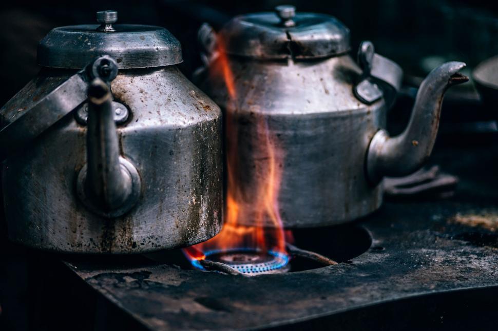 Free Image of Two Tea Kettles Boiling on Stove With Flames 