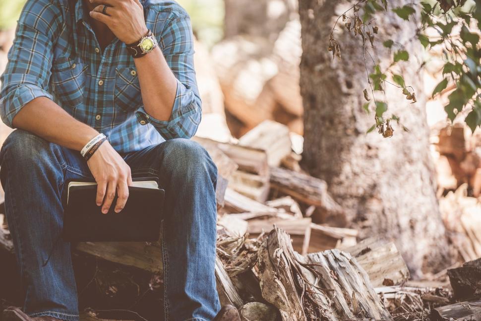 Free Image of Man Sitting on Wooden Bench by Tree 
