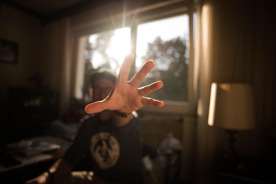 Free Image of Person Extending Hand in Front of Window 
