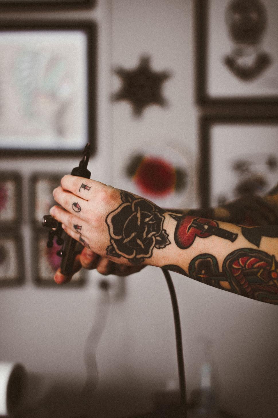 Free Image of Person With Tattoo Holding Hair Dryer 