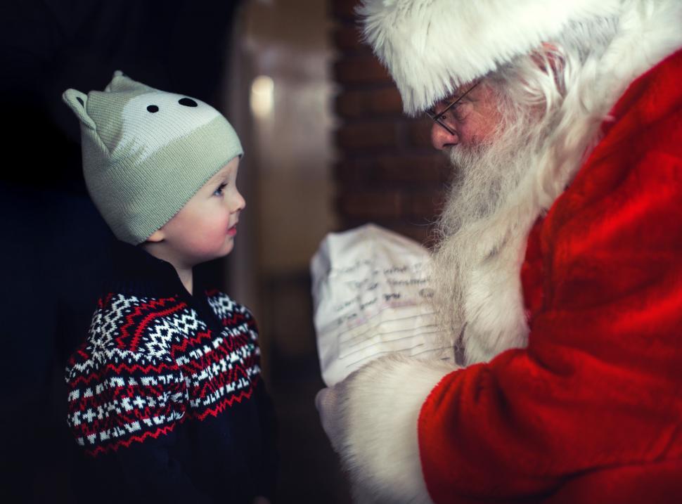 Free Image of Little Boy Standing Next to Santa Claus 