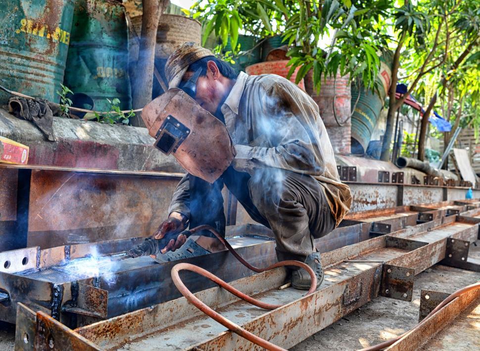 Free Image of Man Working on a Piece of Metal 