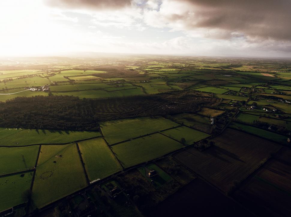 Free Image of Aerial View of Green Field Under Cloudy Sky 