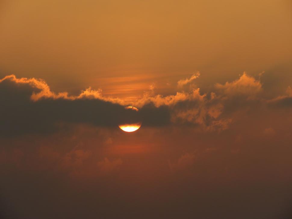Free Image of Sun Setting Over Clouds in Sky 