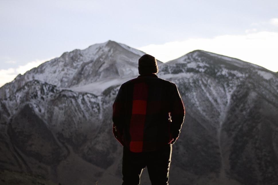 Free Image of Man Standing on Snow-Covered Mountain Top 