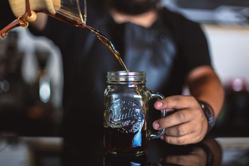 Free Image of Person Pouring Drink Into Mason Jar 