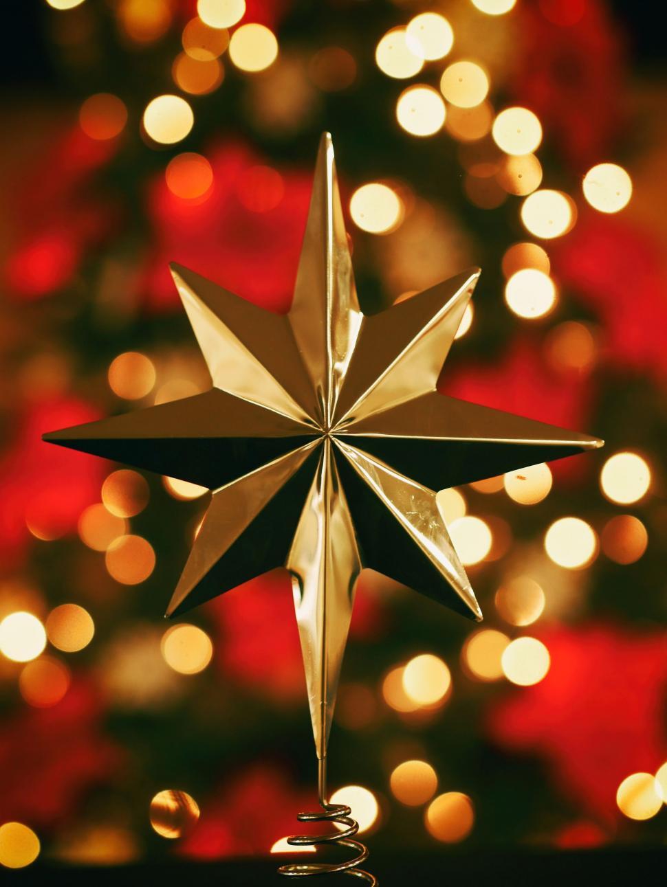 Free Image of Star Ornament in Front of Christmas Tree 