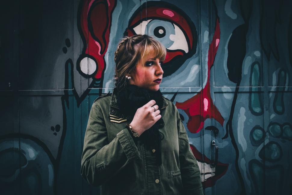 Free Image of Woman Standing in Front of Graffiti Wall 