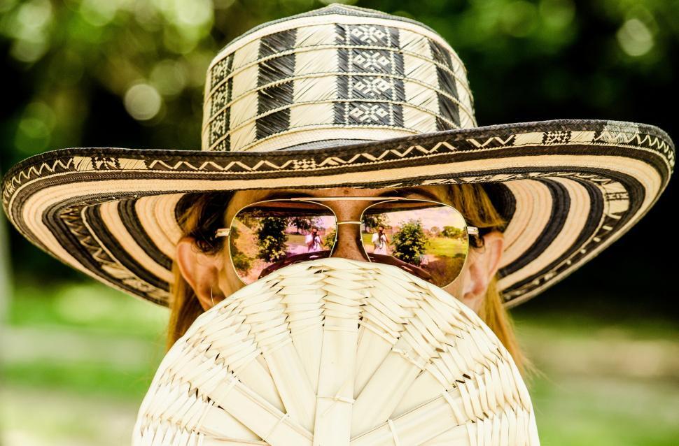 Free Image of Man in Sombrero and Sunglasses Holding a Fan 