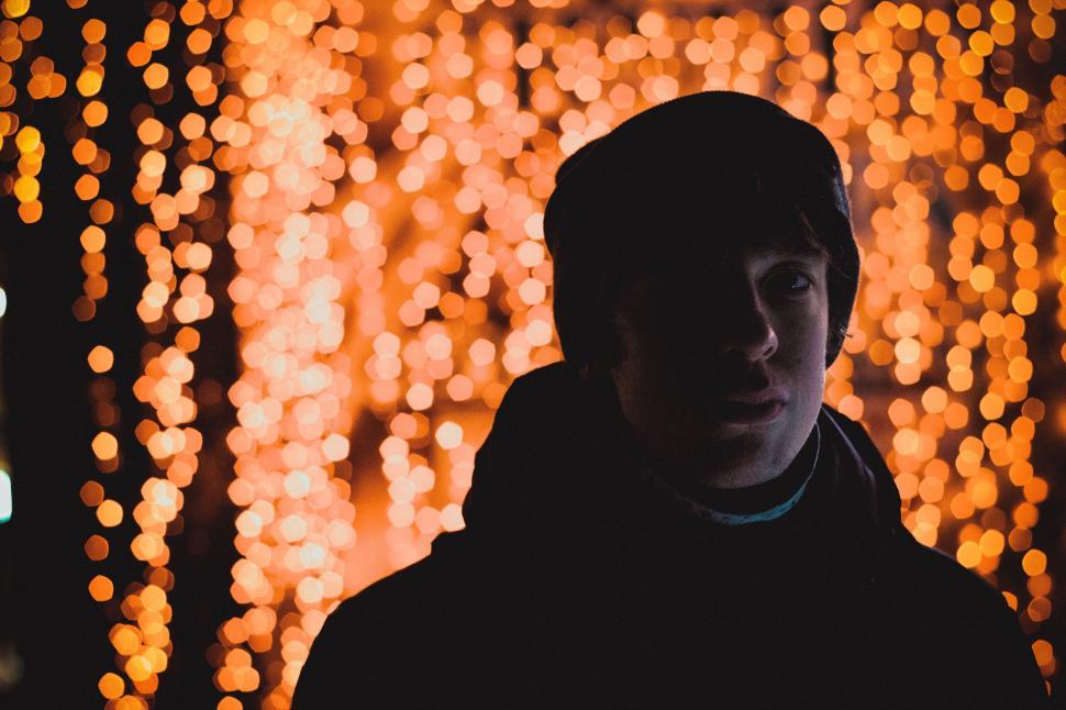 Free Image of Man Standing in Front of Wall of Lights 