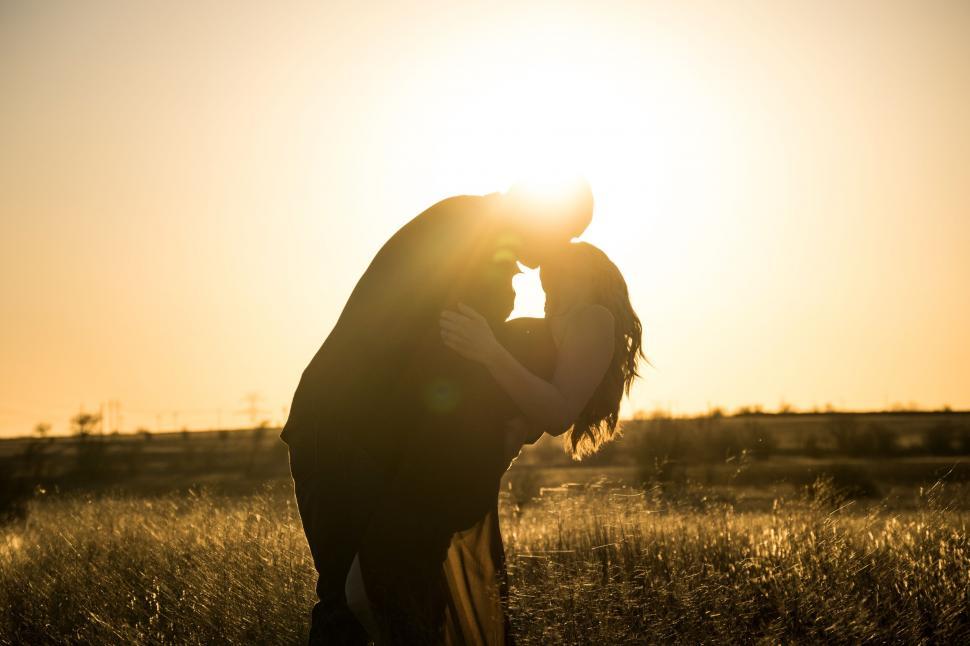 Free Image of Person Standing in Field With Sun Behind 