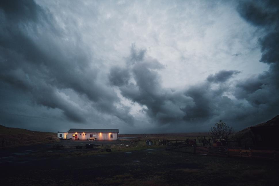 Free Image of House Standing in Field Under Cloudy Sky 
