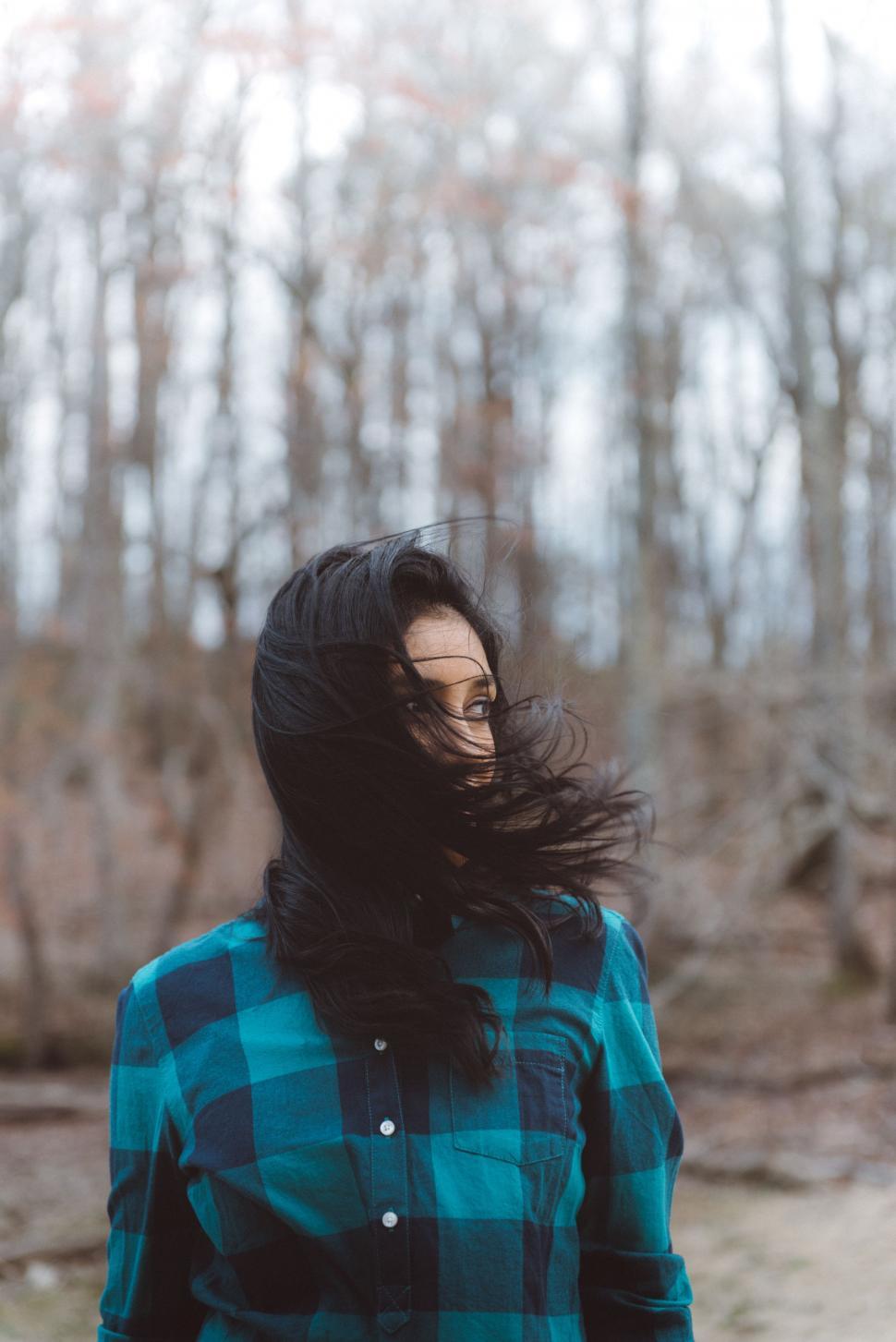 Free Image of Woman With Long Hair Standing in Front of Forest 