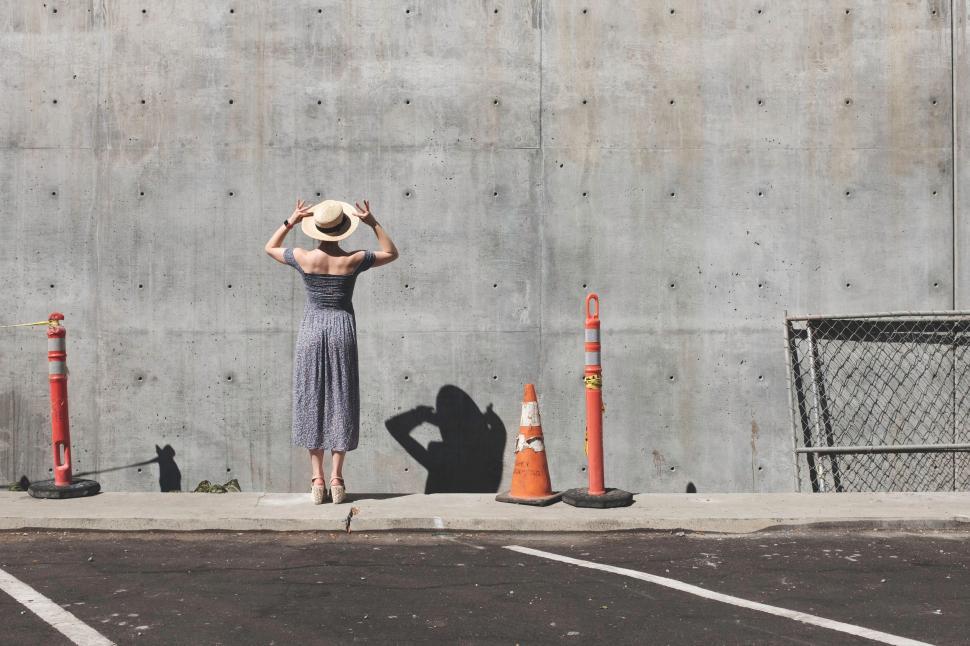Free Image of Woman Standing in Parking Lot With Hat 
