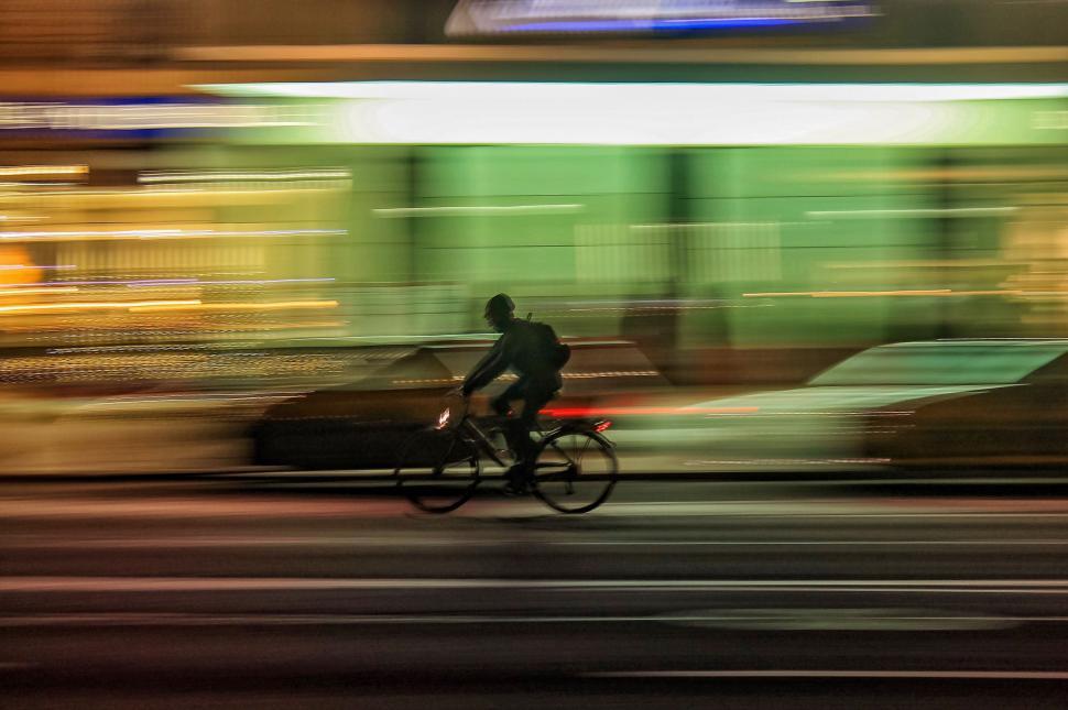 Free Image of Man Riding a Bike Down a Street 