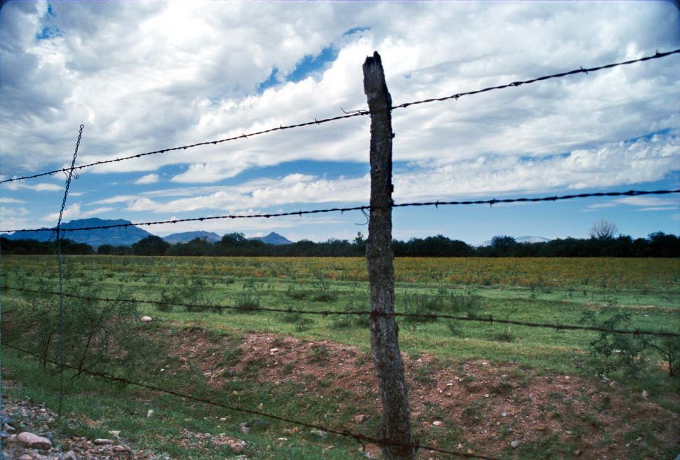 Free Image of barbed wire fence posts clouds fields plains pastures flatlands meadows 