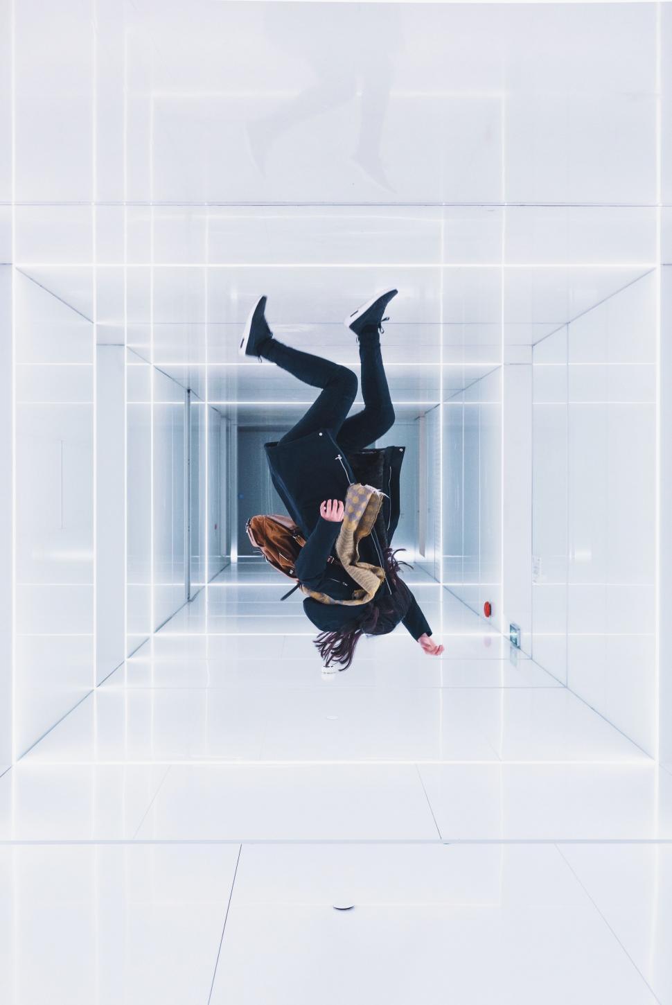 Free Image of Person in Black Suit Upside Down in White Room 