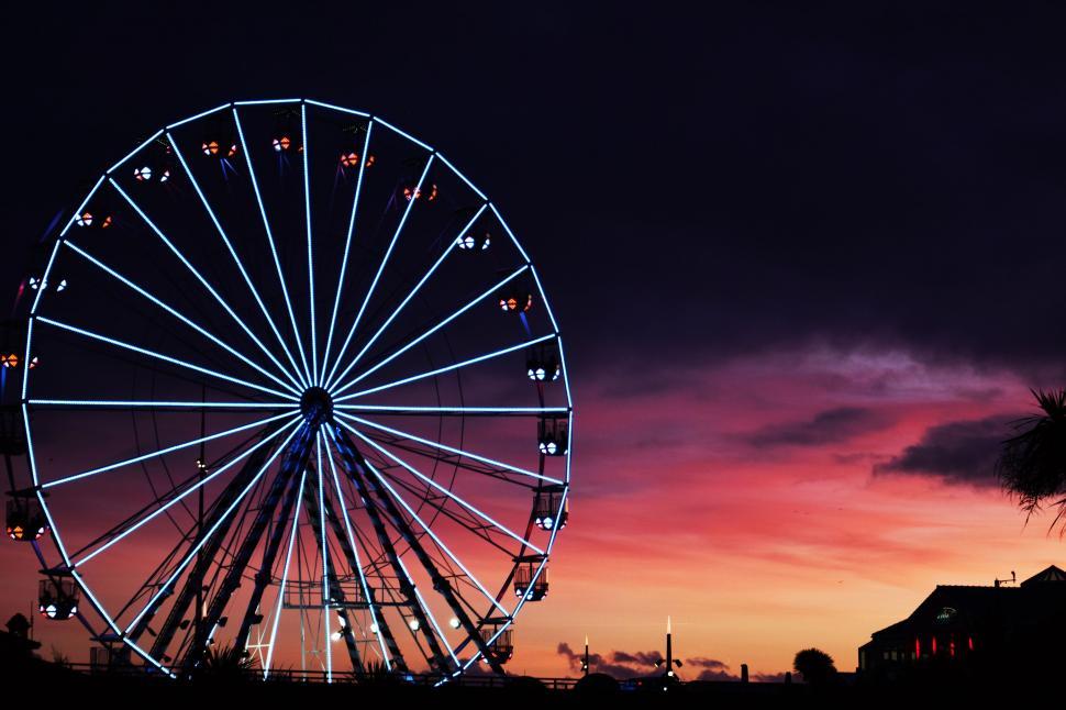 Free Image of Large Ferris Wheel Next to Palm Tree 