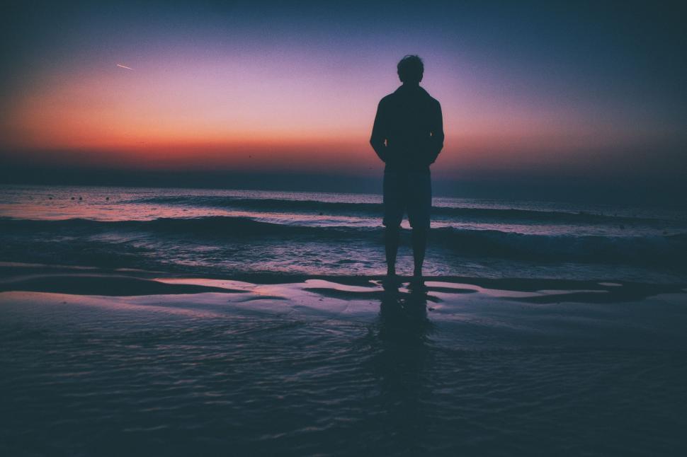Free Image of Man Standing on Beach at Sunset 