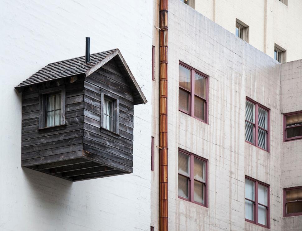 Free Image of Bird House Hanging Off the Side of a Building 