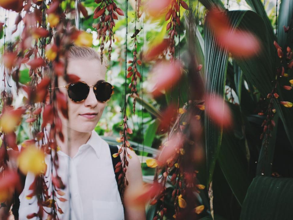 Free Image of Woman Wearing Sunglasses Standing in Front of Tree 
