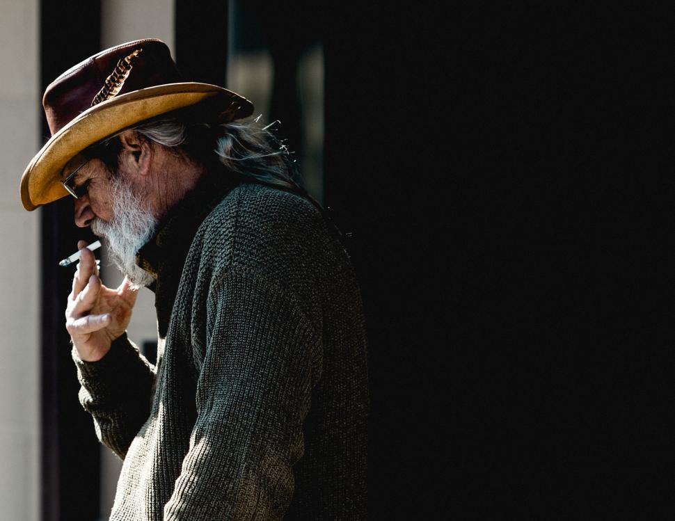 Free Image of Man With Long Beard and Hat Smoking Cigarette 