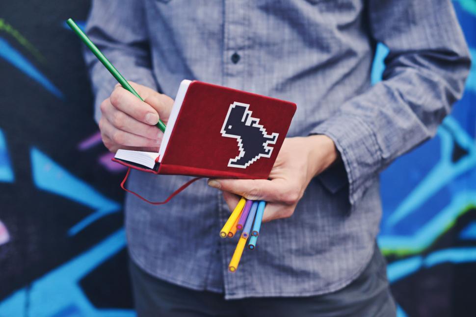 Free Image of Man Holding Notebook With Pixel 