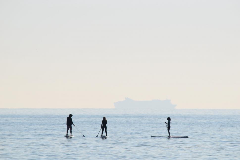Free Image of Group of People Riding Paddle Boards on Water 