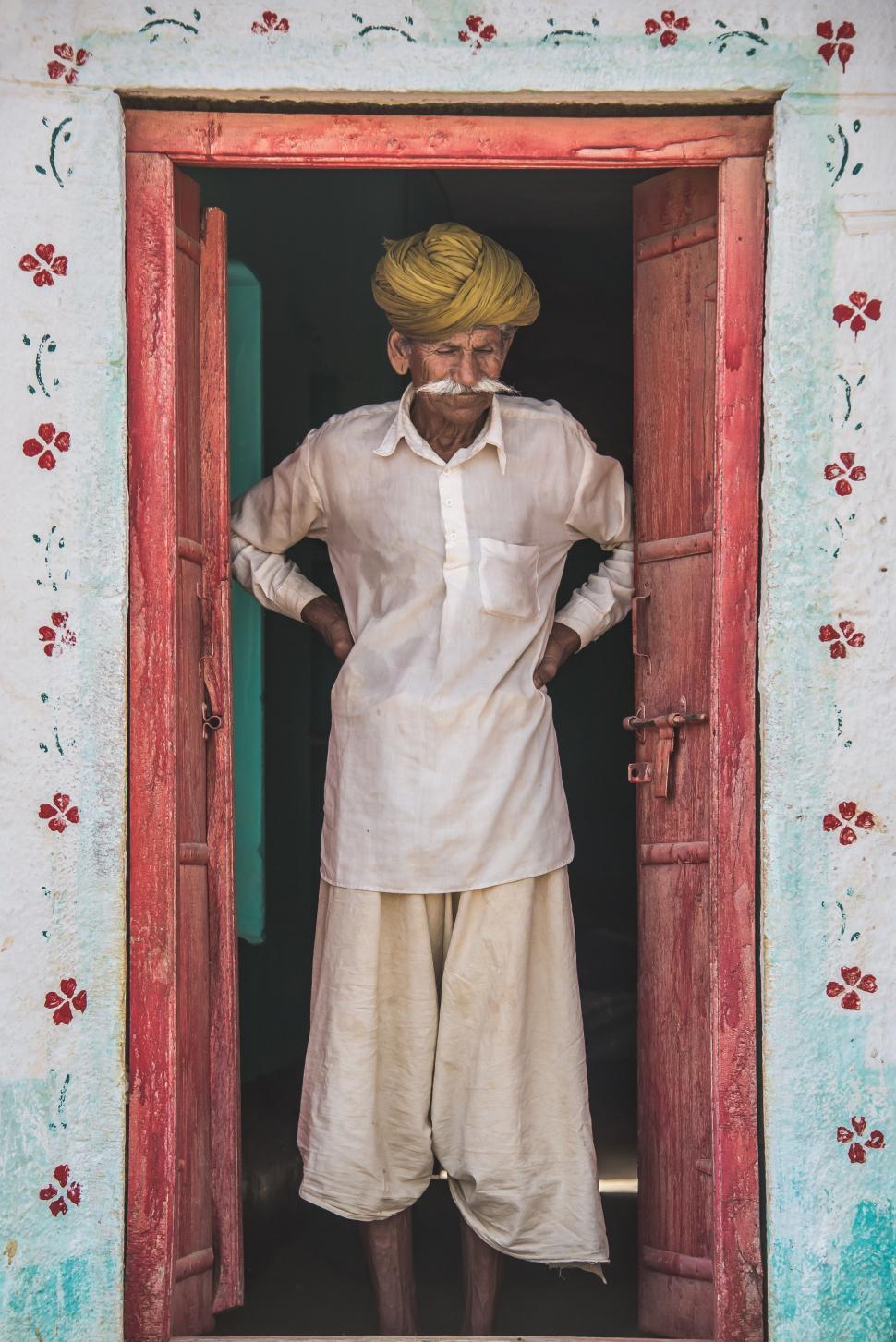 Free Image of Man Standing in Doorway With Hands on Hips 