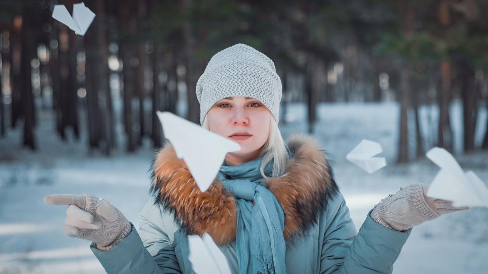 Free Image of Woman in Blue Coat Holding Paper Airplane 