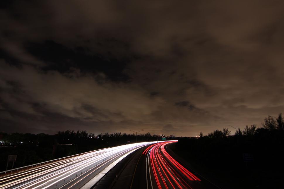 Free Image of Vehicles Streaking Along a Busy Highway at Night 