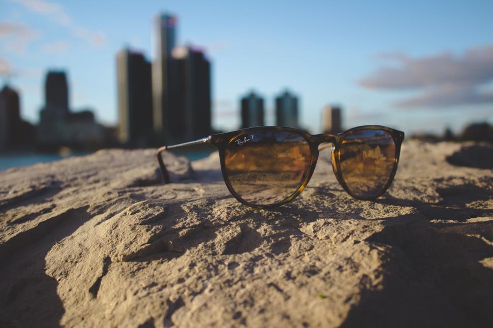 Free Image of Sunglasses Resting on Sandy Beach 