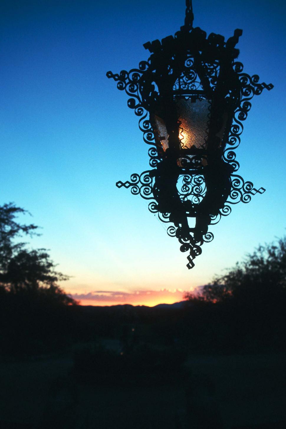 Free Image of lamp hanging ornate metalwork sunset glowing desert sonoran sky 