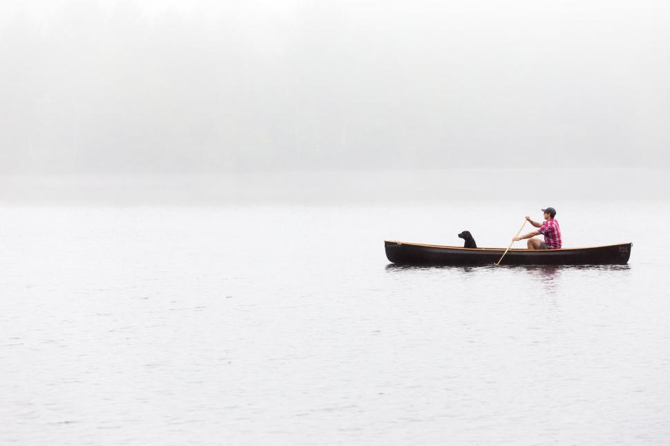 Free Image of Man and Dog Canoeing on Foggy Day 
