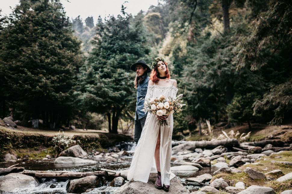 Free Image of Bride and Groom Standing on Rock in Stream 