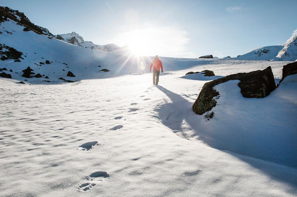 Free Image of Person Walking Up Snow Covered Mountain 
