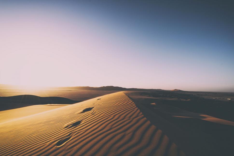 Free Image of Sun Shining Over Sand Dune 
