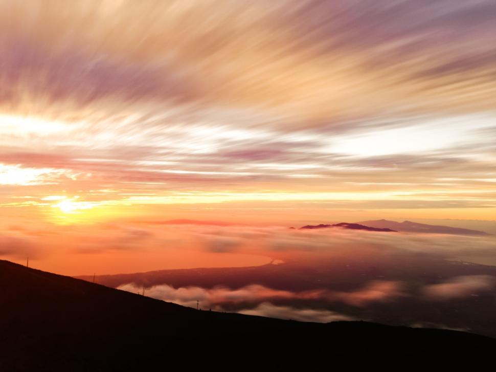 Free Image of Person Standing on Top of a Mountain at Sunset 