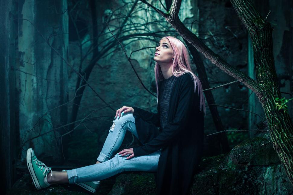 Free Image of Woman Sitting on Tree Branch in Woods 