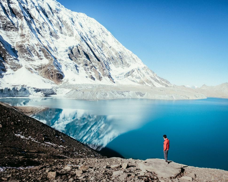 Free Image of Man Standing on Top of Mountain Next to Lake 