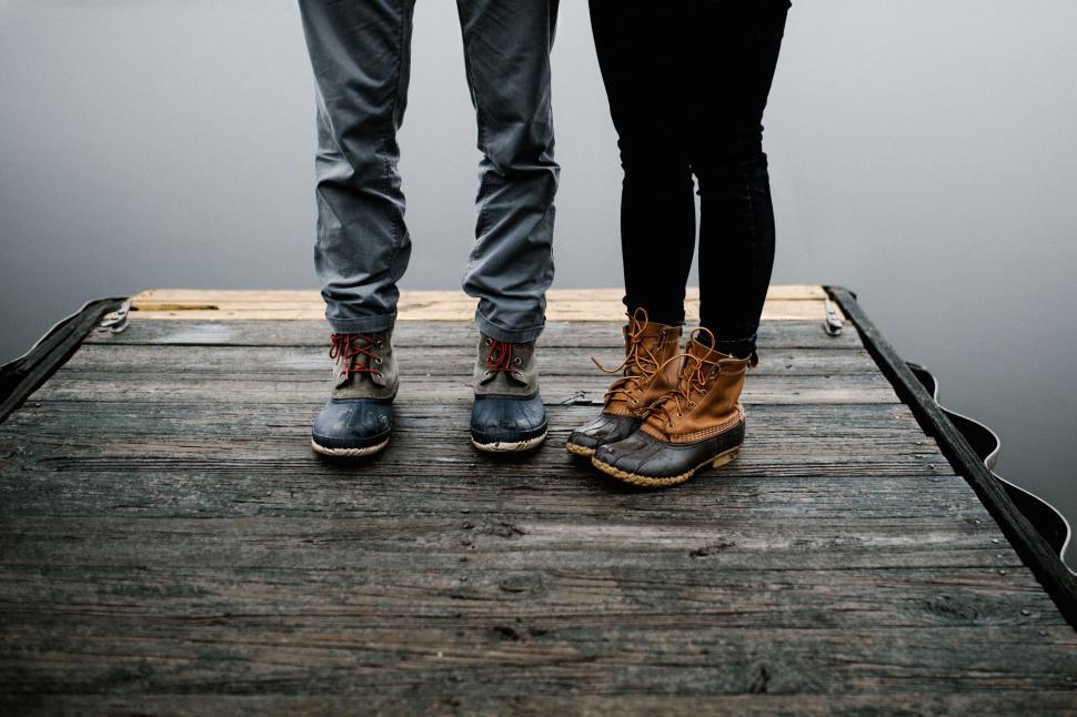 Free Image of Two People Standing on a Dock by Water 