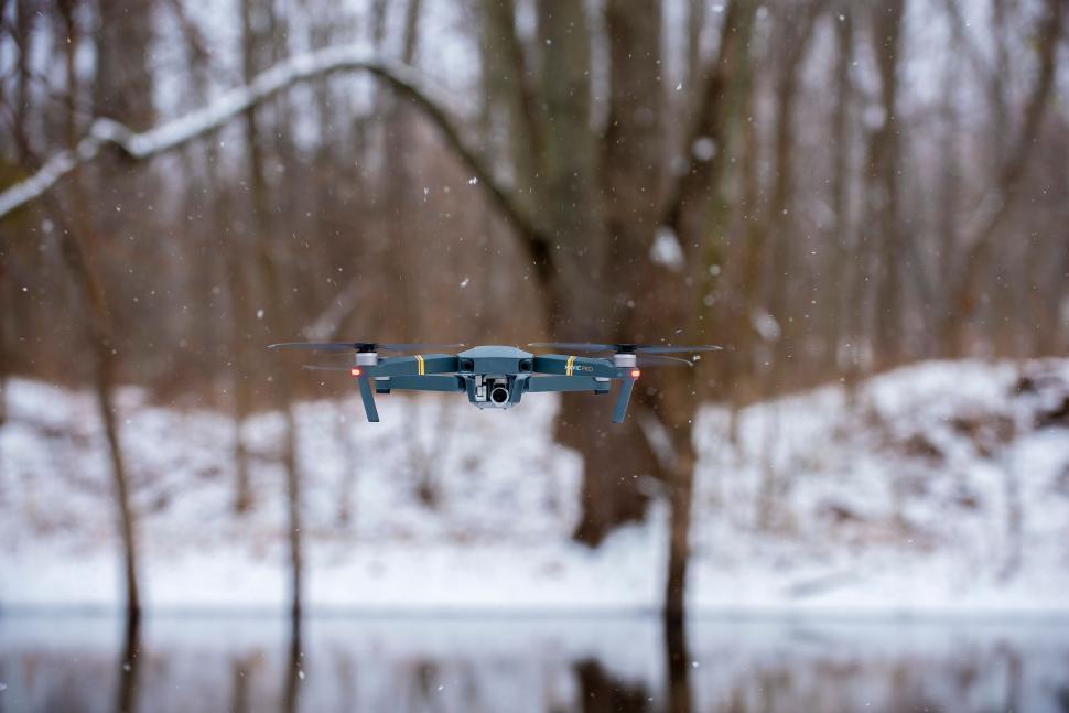 Free Image of Blue and Black Remote Controlled Flying Device in Snowy Forest 